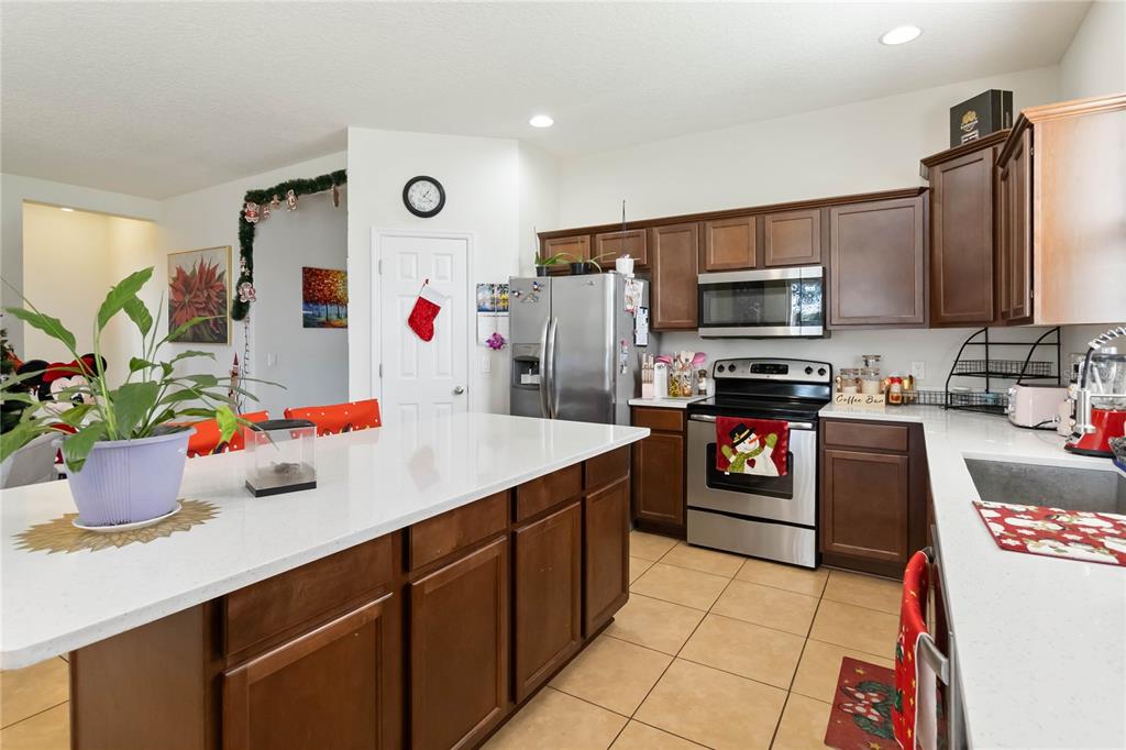 4042 Eternity Circle St. Cloud, FL 34772 - Photo 12 of 35 a kitchen with stainless steel appliances kitchen island granite countertop a sink and cabinets