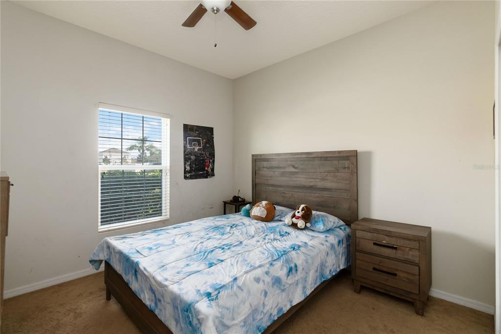 4042 Eternity Circle St. Cloud, FL 34772 - Photo 16 of 35 a bedroom with a bed and a window
