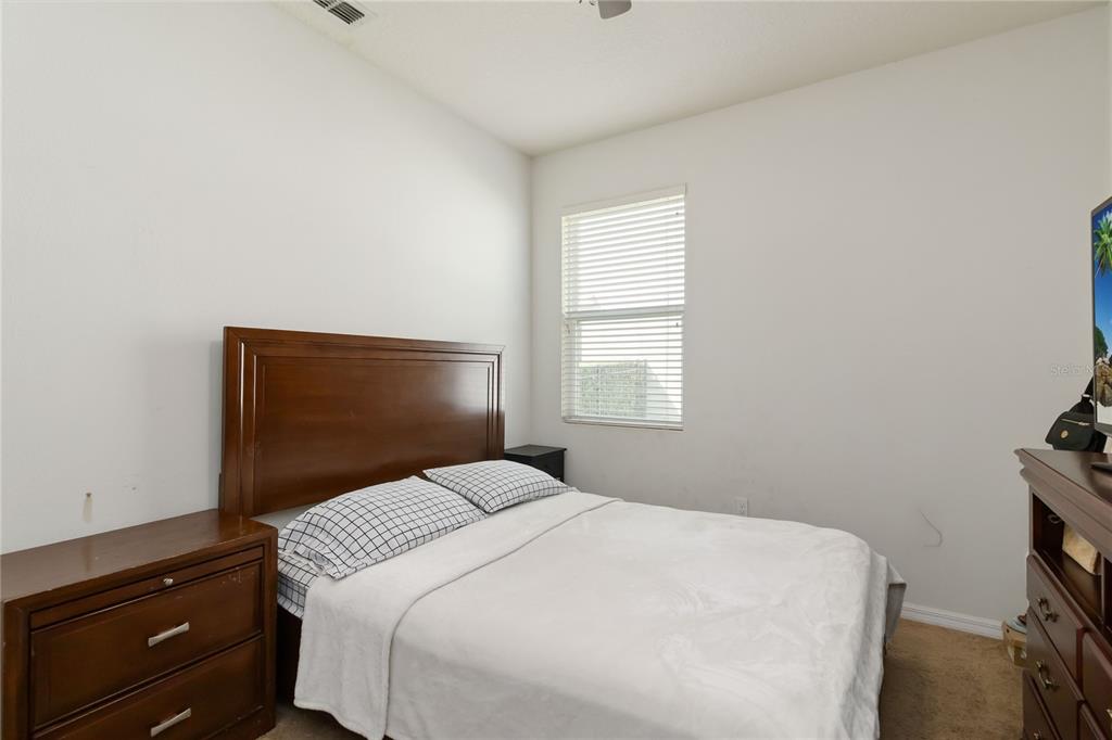 4042 Eternity Circle St. Cloud, FL 34772 - Photo 19 of 35 a bedroom with a bed and a window