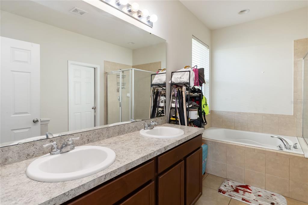 4042 Eternity Circle St. Cloud, FL 34772 - Photo 23 of 35 a bathroom with a granite countertop sink and a mirror