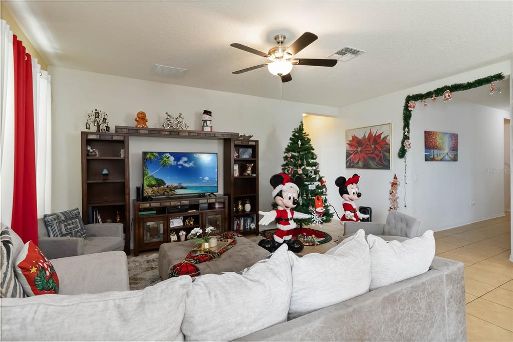4042 Eternity Circle St. Cloud, FL 34772 - Photo 10 of 35 a living room with furniture and a flat screen tv