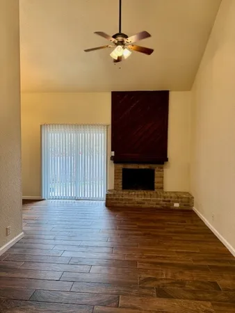 a view of a livingroom with wooden floor and a ceiling fan