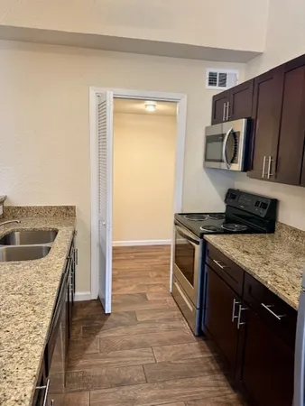 a kitchen with stainless steel appliances granite countertop a stove and a sink