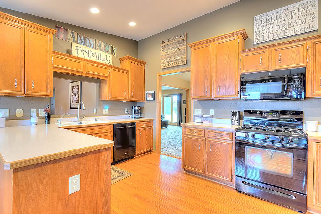 5948 Mc Donald Road Roscoe, IL 61073 - Photo 15 of 24 a kitchen with stainless steel appliances granite countertop a stove a sink and a microwave