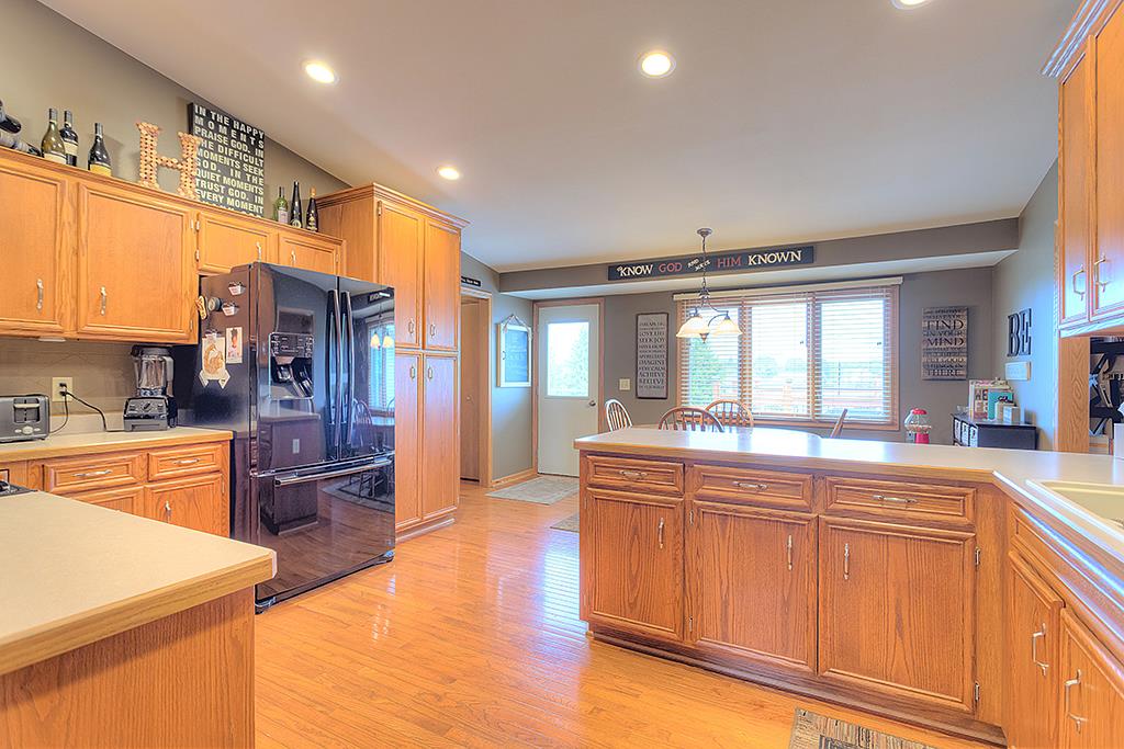 5948 Mc Donald Road Roscoe, IL 61073 - Photo 16 of 24 a large kitchen with stainless steel appliances granite countertop a refrigerator and a stove top oven