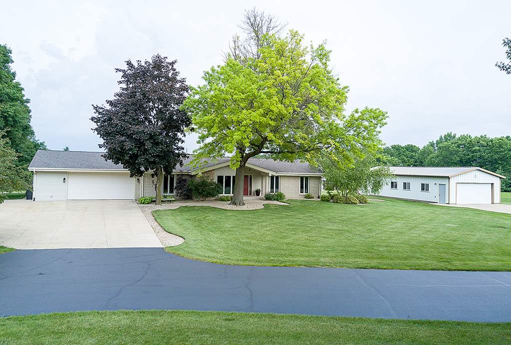 5948 Mc Donald Road Roscoe, IL 61073 - Photo 6 of 24 a front view of a house with a garden and trees