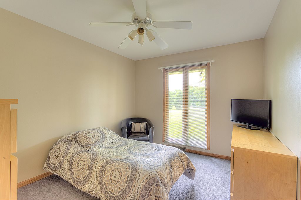 5948 Mc Donald Road Roscoe, IL 61073 - Photo 10 of 24 a bedroom with a bed and a flat tv screen on the dresser