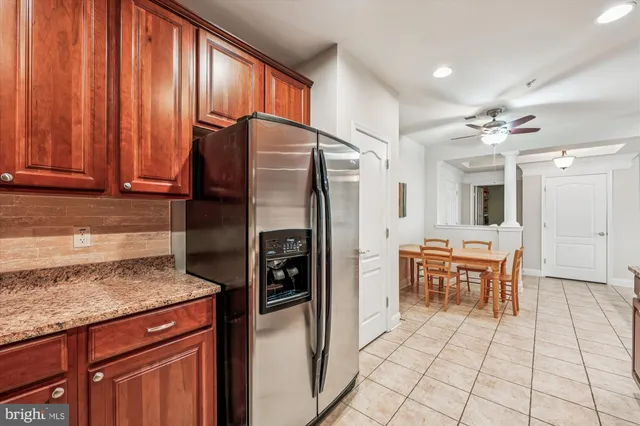 a kitchen with stainless steel appliances granite countertop a refrigerator and a stove top oven