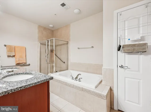 a bathroom with a granite countertop sink a toilet a mirror and shower