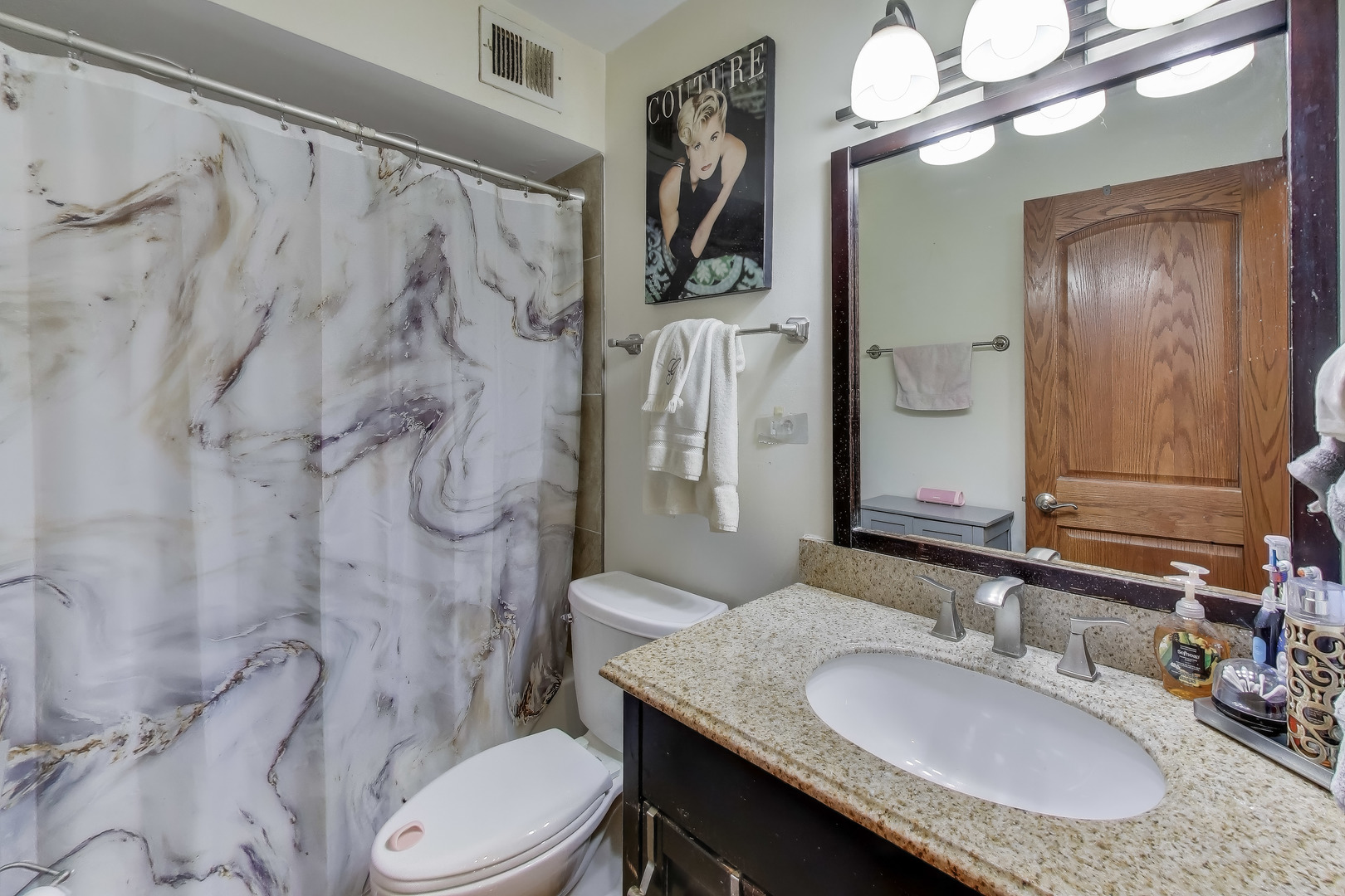 20 North Tower Road, Unit 8E Oak Brook, IL 60523 - Photo 21 of 31 a bathroom with a granite countertop sink toilet a mirror a vanity and shower