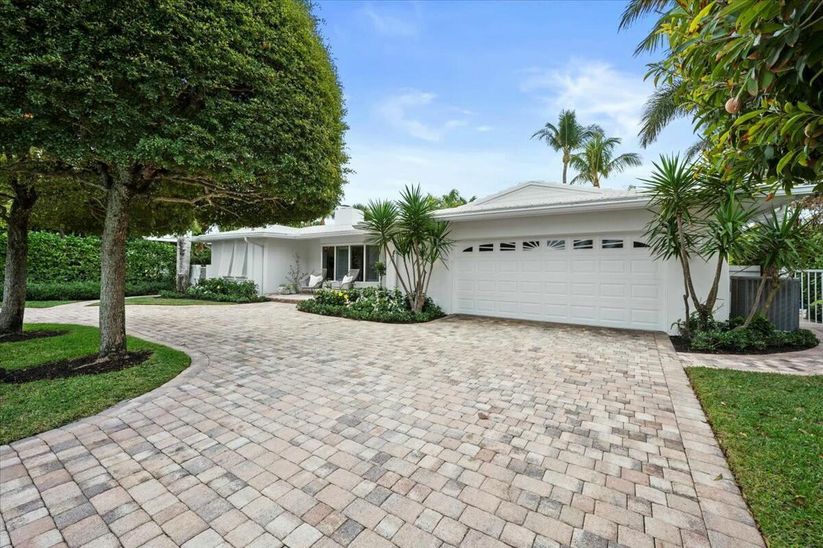 232 Cove Place Jupiter, FL 33469 - Photo 5 of 67 a front view of a house with a yard and a garage