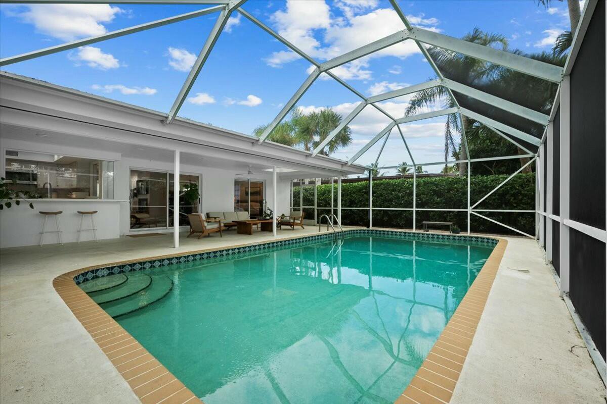 232 Cove Place Jupiter, FL 33469 - Photo 52 of 67 a view of a swimming pool with a patio and a yard