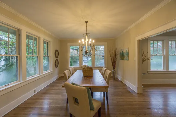 a kitchen with stainless steel appliances granite countertop a stove a refrigerator and a dining table with wooden cabinet