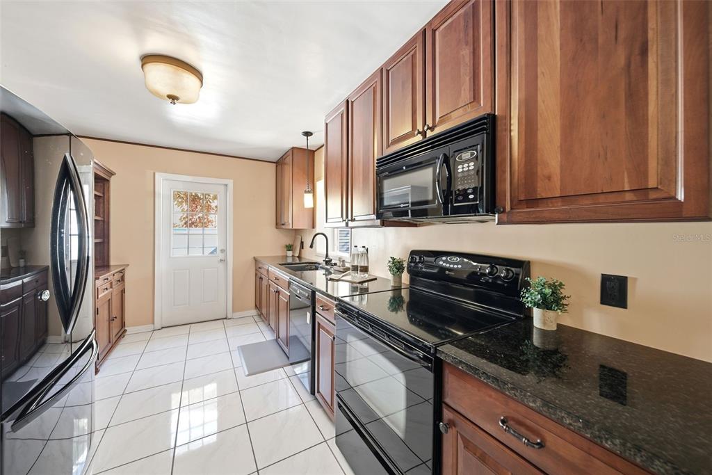 1715 Canton Street Orlando, FL 32803 - Photo 13 of 31 a kitchen with stainless steel appliances granite countertop a stove a sink and a microwave