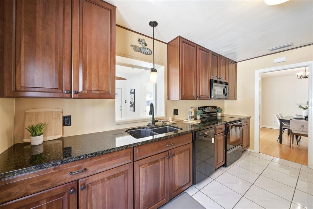 1715 Canton Street Orlando, FL 32803 - Photo 14 of 31 a kitchen with stainless steel appliances granite countertop a sink stove and cabinets