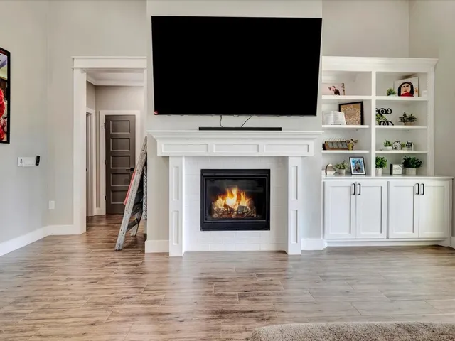 a living room with a fireplace and a flat screen tv