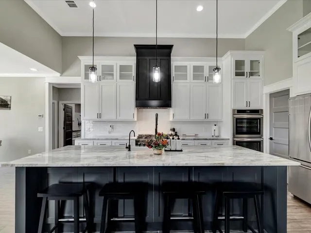 a kitchen with a wooden floor and chairs