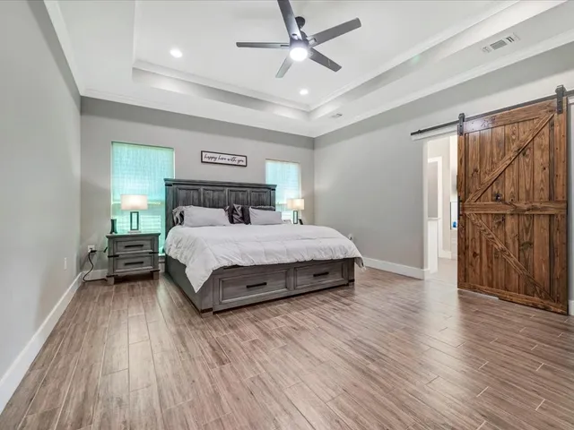 a bedroom with a bed and wooden floor