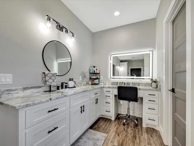 a en suite bathroom with a granite countertop sink and a mirror