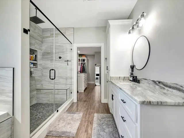 a spacious bathroom with a granite countertop sink mirror and shower