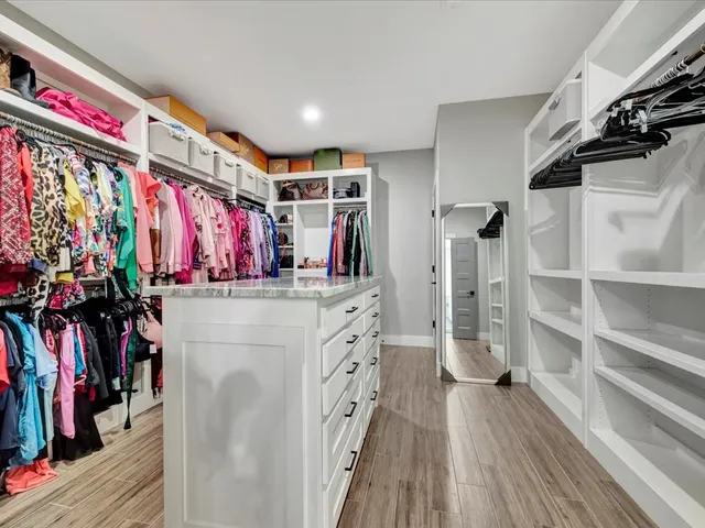 a view of walk in closet with clothes and shoes