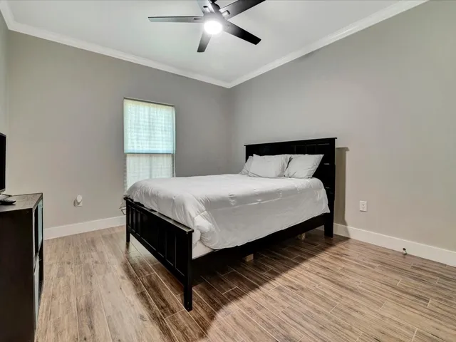 a bedroom with a bed and a flat tv screen on dresser