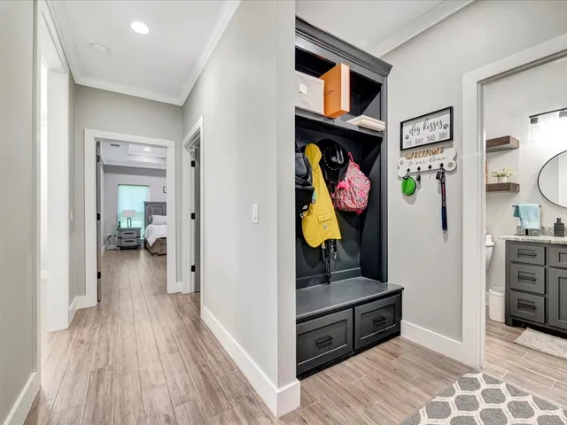 a view of a hallway and a livingroom with wooden floor and a bathroom
