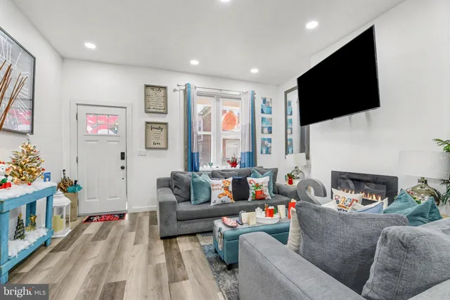 a living room with furniture a flat screen tv and a fireplace