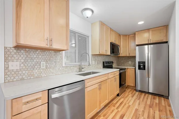 a kitchen with a sink a refrigerator a microwave and cabinets