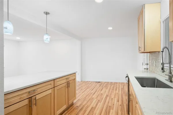 a kitchen with a sink cabinets and wooden floor