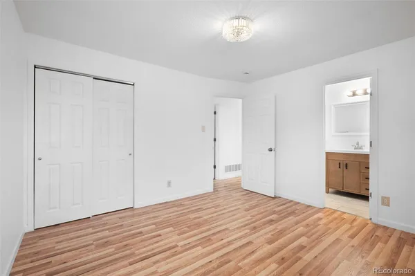 a big room with wooden floor and a bathroom
