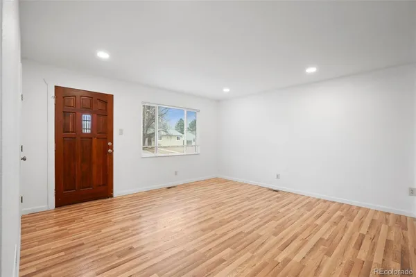 a view of empty room with wooden floor