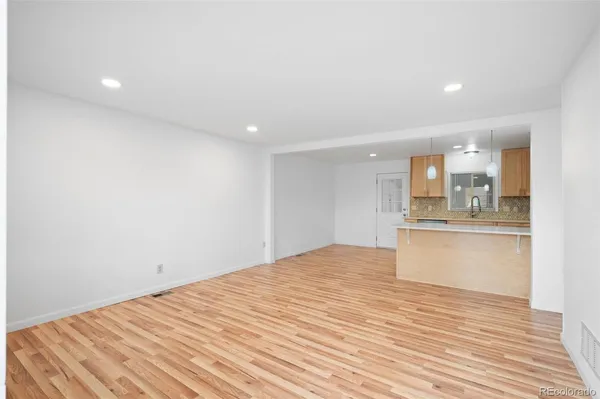 a view of a kitchen with wooden floor and a sink