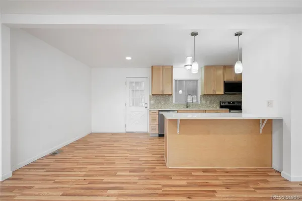 a view of kitchen with granite countertop cabinets and refrigerator