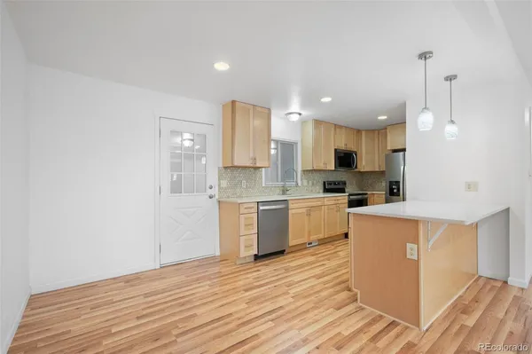 a large kitchen with a lot of counter space and wooden floor