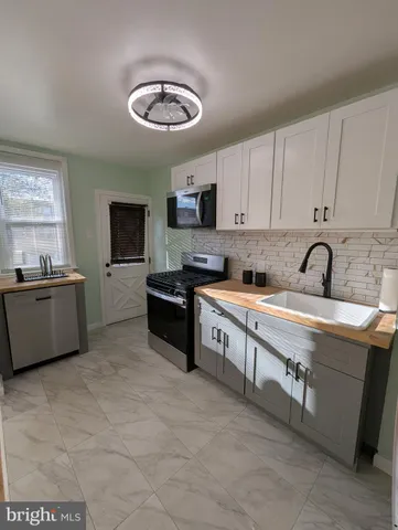 a large kitchen with stainless steel appliances granite countertop a sink and a stove