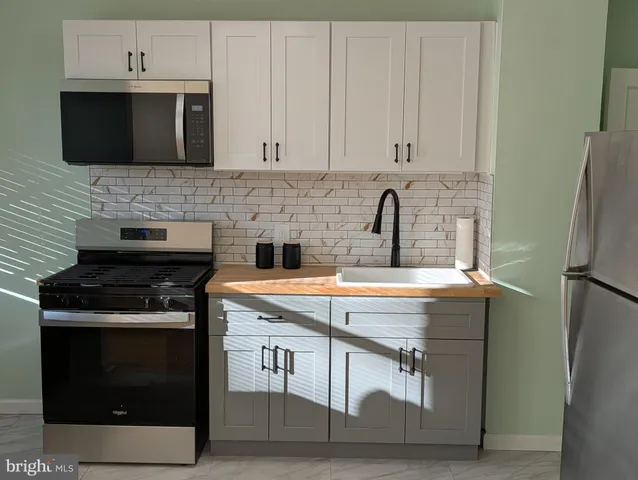 a kitchen with stainless steel appliances granite countertop a stove and a microwave