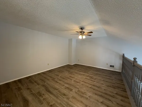 a view of an empty room with a chandelier fan