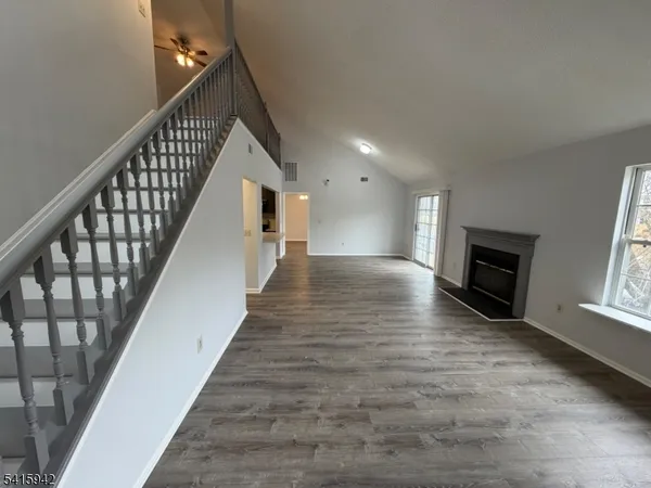 a view of a livingroom with wooden floor and staircase