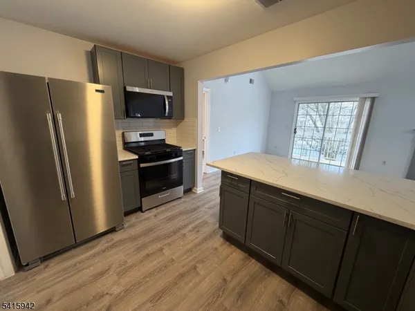 a kitchen with granite countertop a refrigerator and a sink