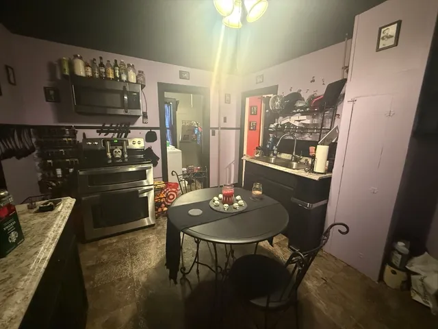 a kitchen with stainless steel appliances kitchen island granite countertop a table and chairs