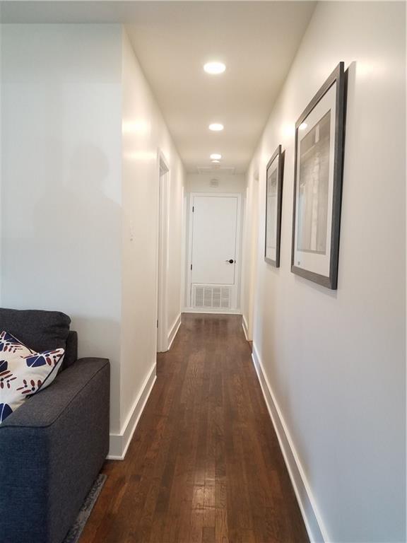 5405 Hudson Street Austin, TX 78721 - Photo 22 of 37 A well-lit corridor boasts rich hardwood flooring and sleek recessed lighting.