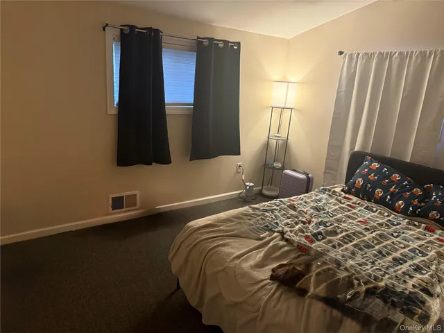 a bedroom with a bed and a flat tv screen on a dresser