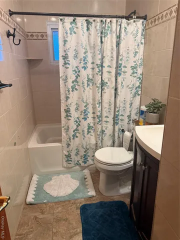 a white toilet sitting next to a bath tub and a shower