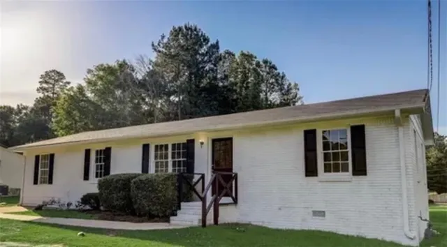 a front view of a house with yard and green space