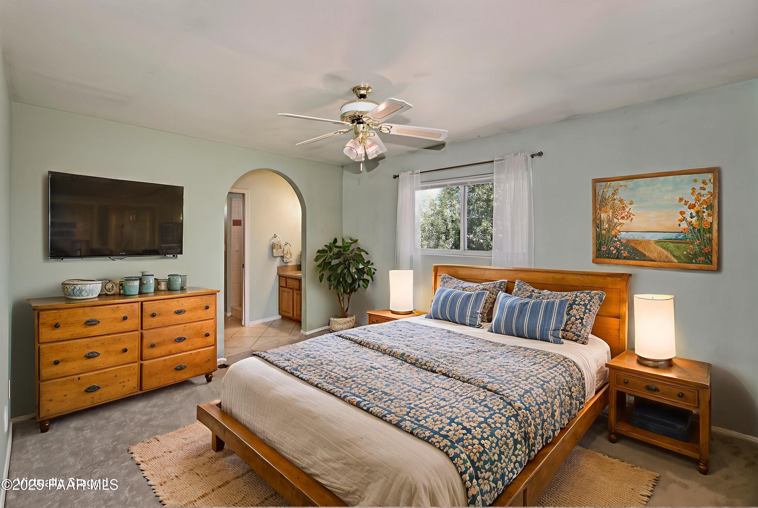 11800 West Faded Whistle Road Prescott, AZ 86305 - Photo 24 of 65 a spacious bedroom with a bed and a flat screen television