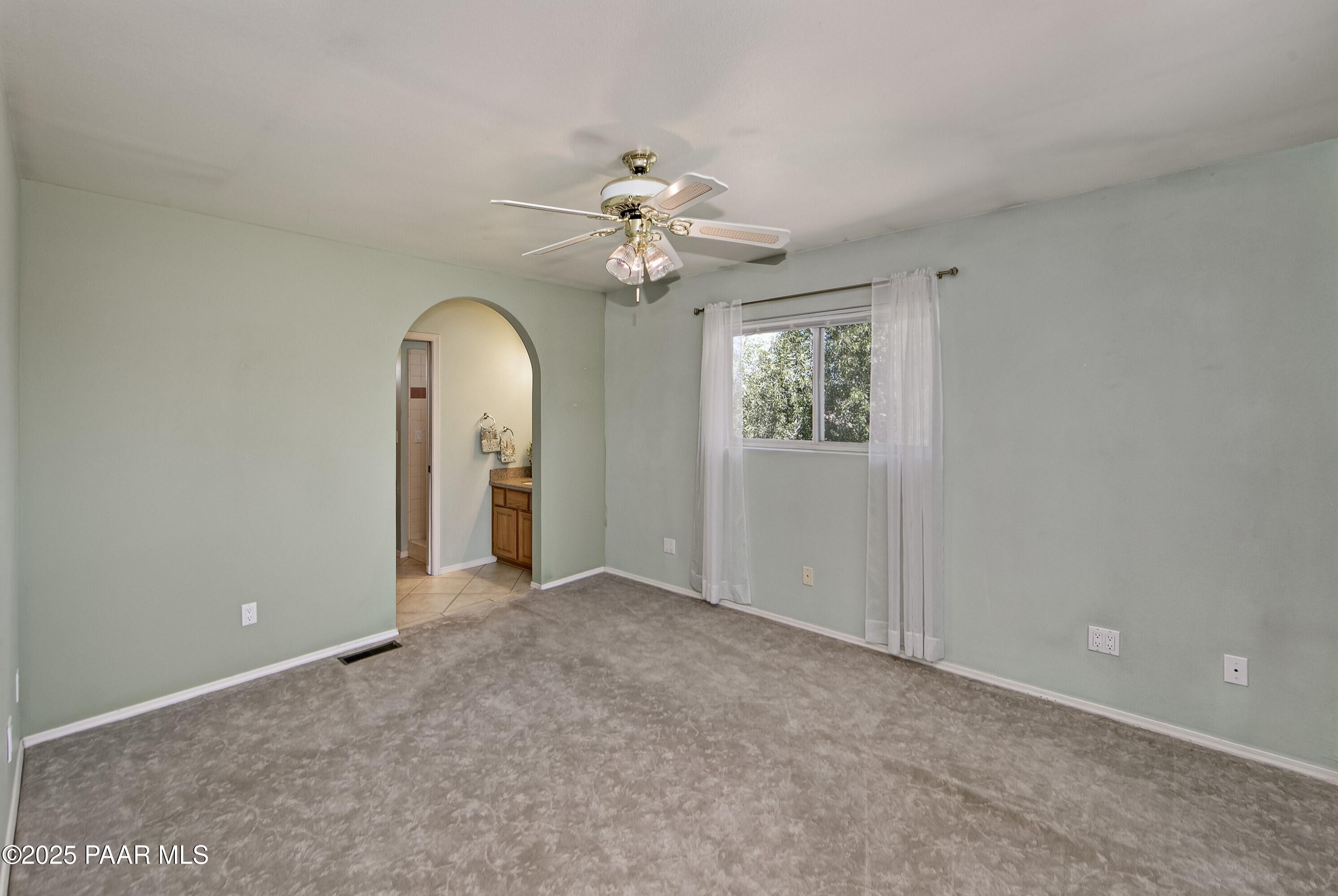 11800 West Faded Whistle Road Prescott, AZ 86305 - Photo 25 of 65 an empty room that has a window and a chandelier fan