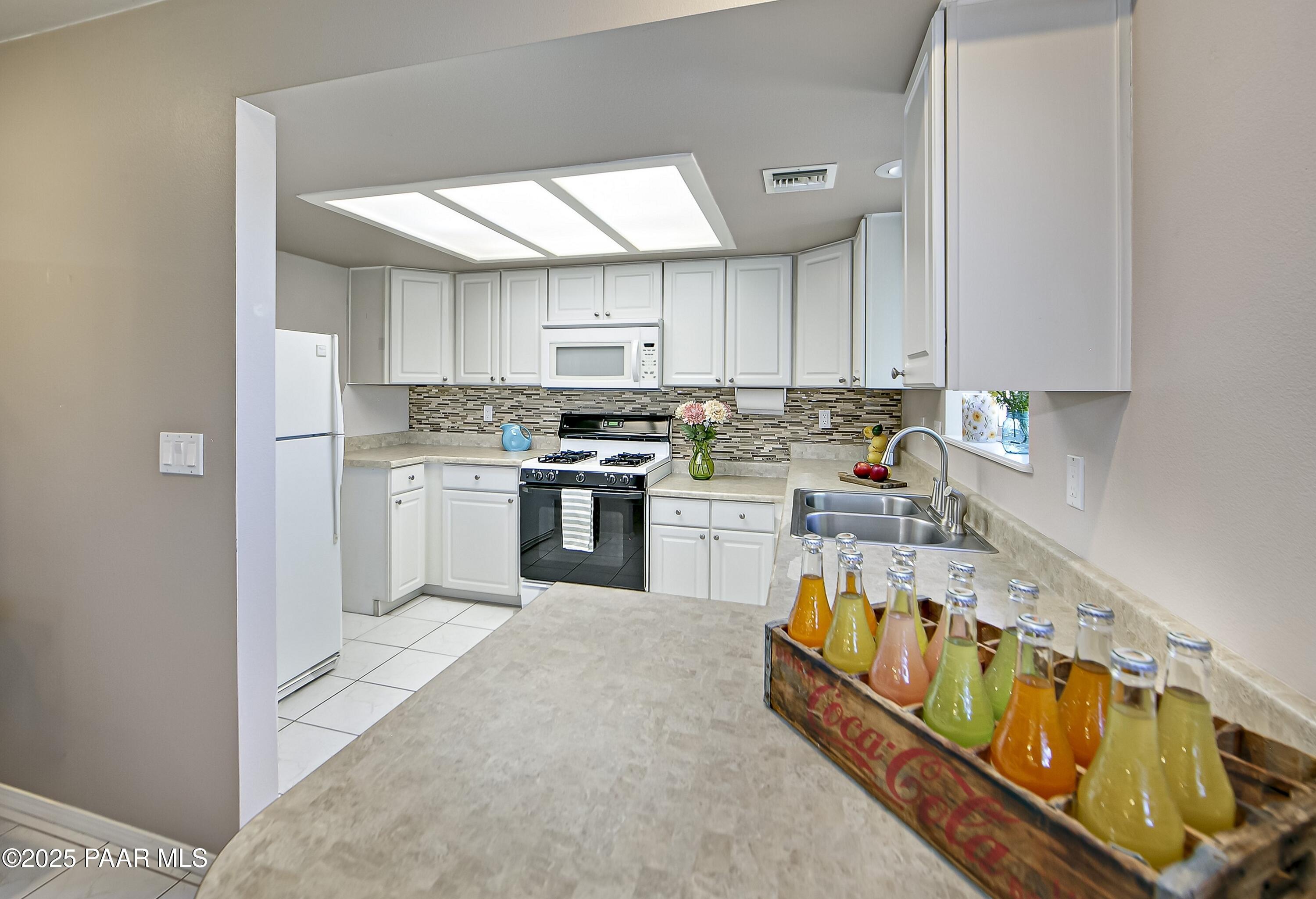 11800 West Faded Whistle Road Prescott, AZ 86305 - Photo 38 of 65 a kitchen with stainless steel appliances granite countertop a stove a sink dishwasher and a refrigerator