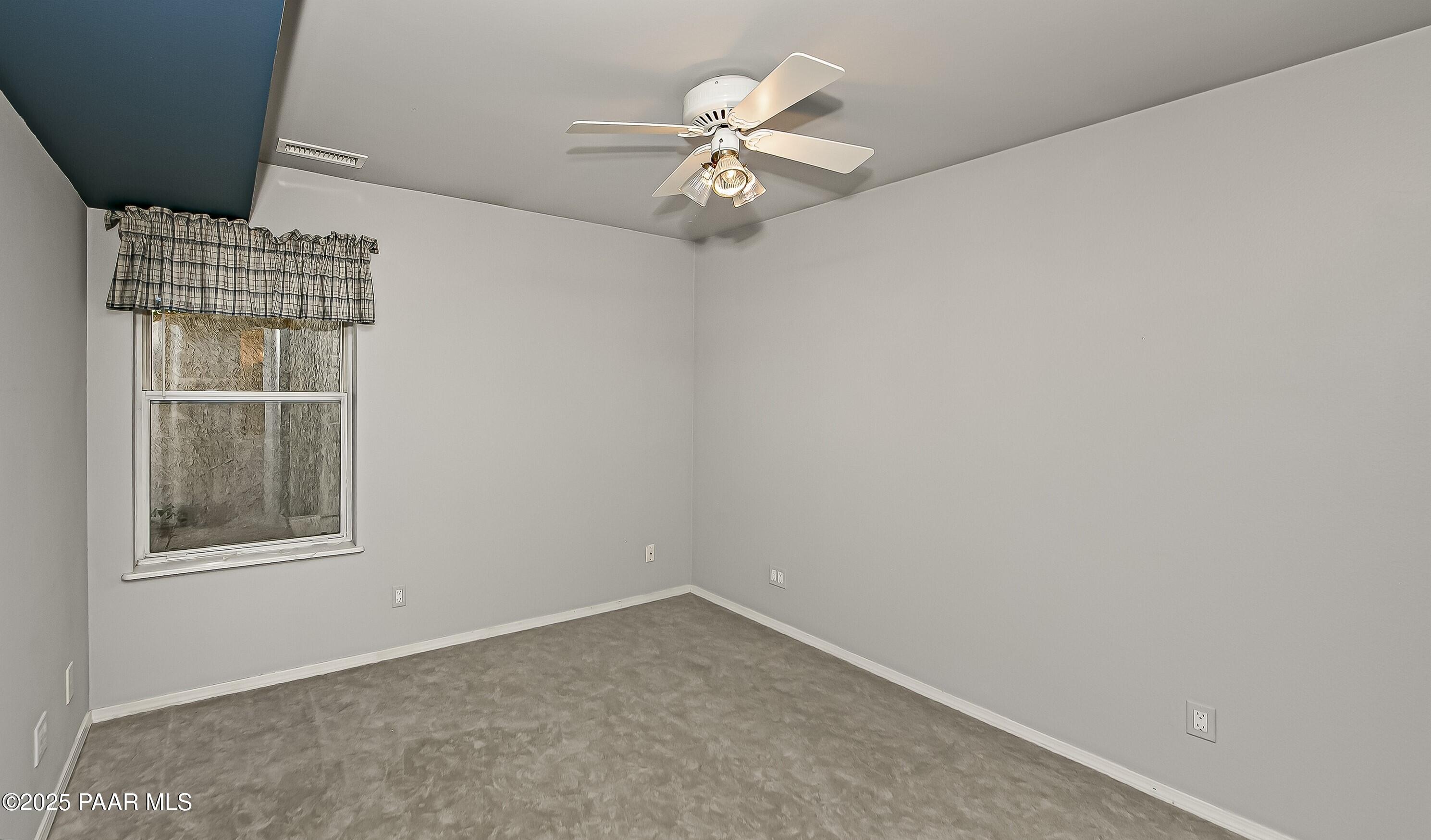 11800 West Faded Whistle Road Prescott, AZ 86305 - Photo 41 of 65 an empty room with windows and ceiling fan