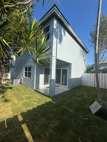 a front view of house with yard and trees in the background
